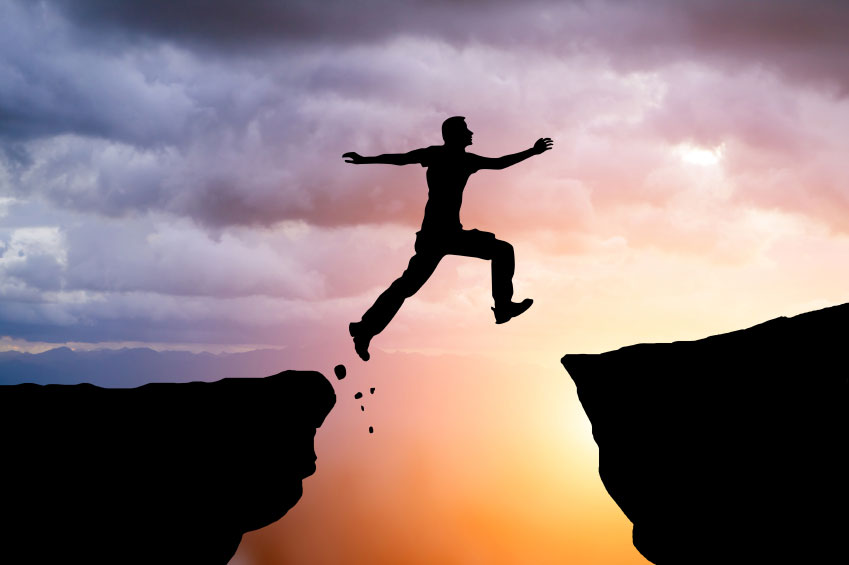 Crossing the chasm - man jumping cliff to cliff - What is a transformational leader